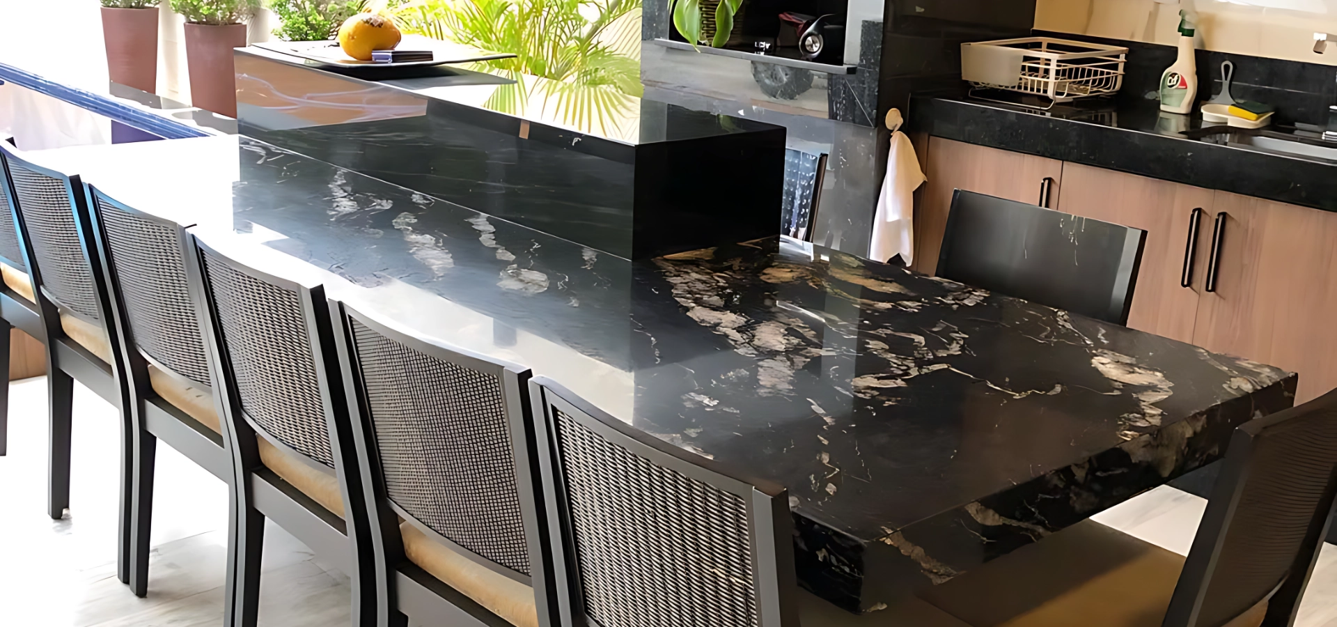 Área gourmet bancada ilha, pia e cooktop. material utilizado granito preto via láctea e granito preto